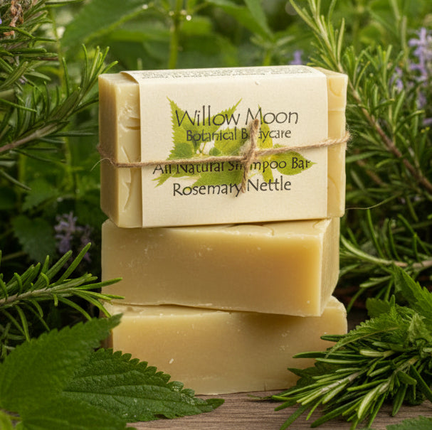 Three stacked natural soap bars wrapped in kraft paper with a label reading Willow Moon Botanical Care, Rosemary & Nettle, tied with twine, on a wooden surface with rosemary sprigs.