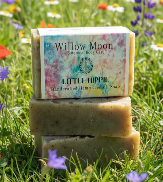 Little Hippie Patchouli and Peppermint stack of soaps with the top one showing the tie dye label in a field of wild flowers